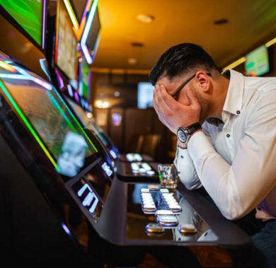 Men loosing his money on slot machine in the casino.